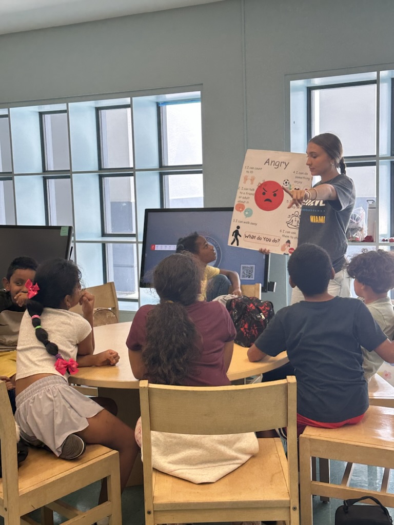 Adriana teaching students to recognize anger with an emotion poster